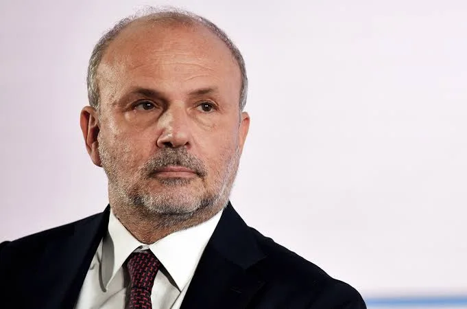 Orazio Schillaci in a close portrait against a pale background, wearing a dark suit and white shirt