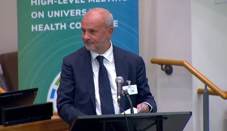 Orazio Schillaci at a lectern beside a green banner reading 'High-level meeting on Universal Health Coverage'