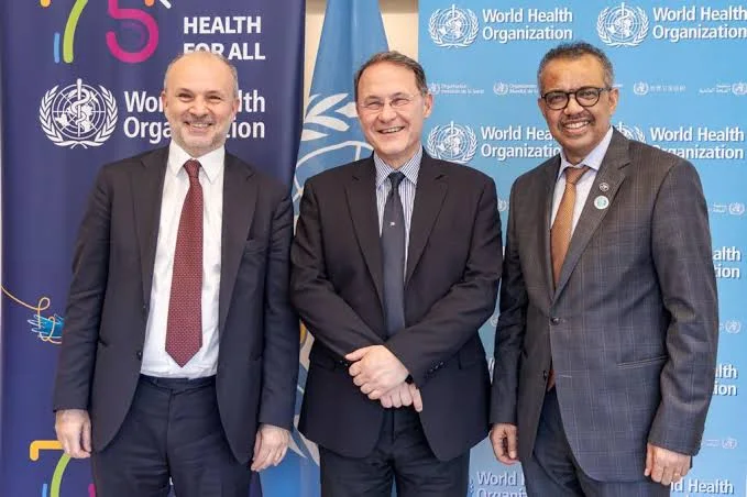 Orazio Schillaci with WHO Director-General Tedros Adhanom Ghebreyesus and another delegate in front of World Health Organization backdrops