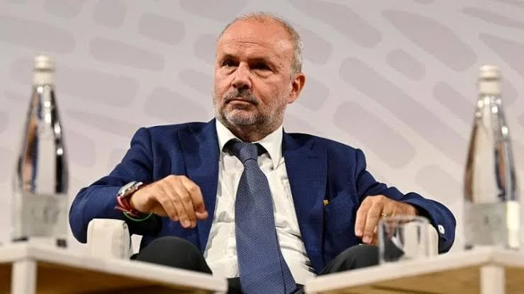 Orazio Schillaci seated in an armchair on a conference stage during a panel discussion, with water bottles on side tables